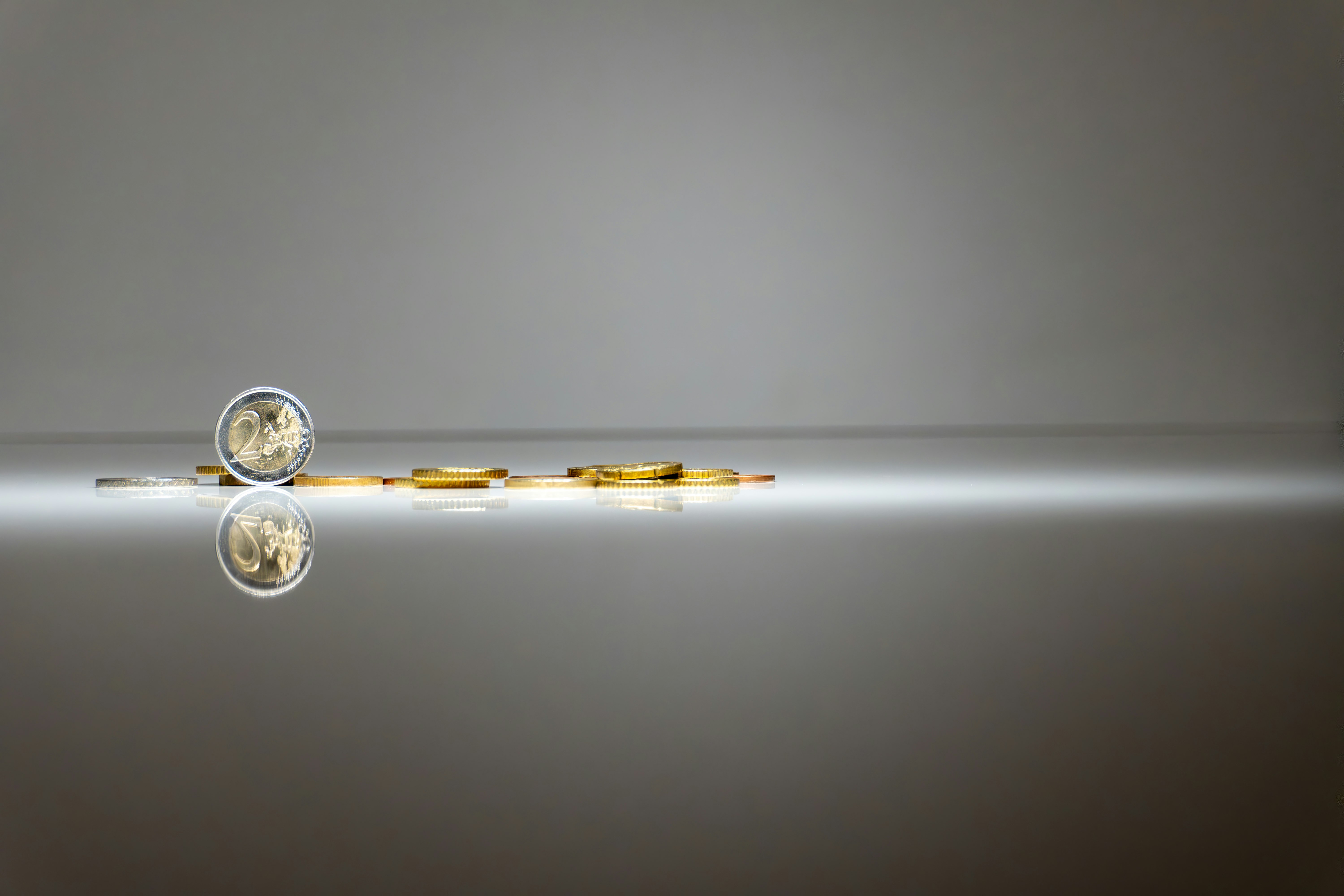 a pair of gold coins sitting on a reflective surface